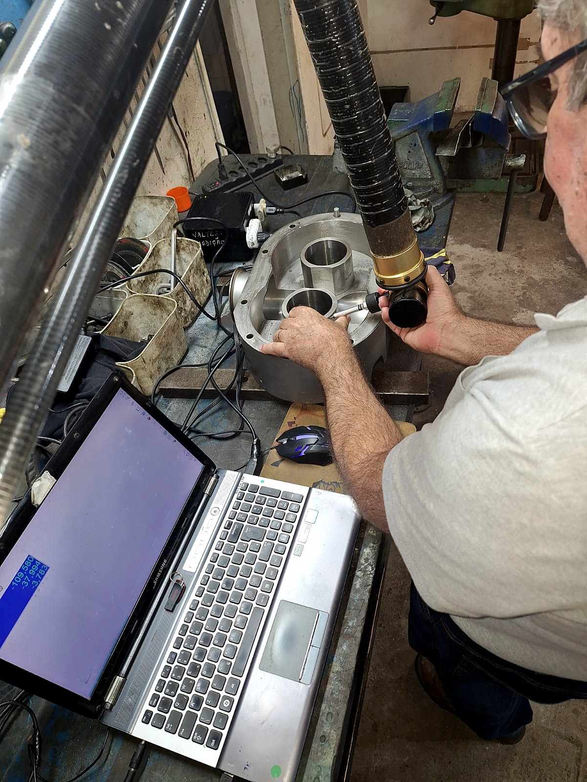 Técnico da FMC trabalhando numa carcaça, com o notebook ao lado
